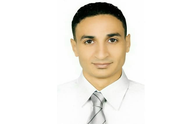 Headshot photo of a man wearing a collared shirt with a tie.