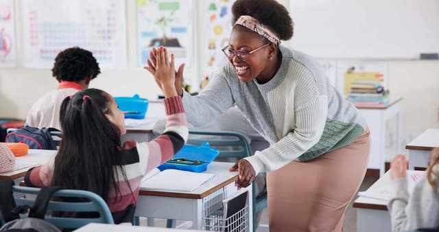 A smiling woman and a child performing a high-five.