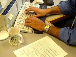 Hands typing on a keyboard.
