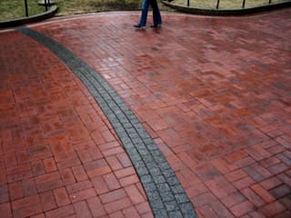 Photo of feet along a brick-paved path.