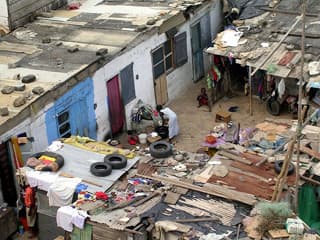 Photo of a group of flimsy makeshift housing for poor families in Ghana.
