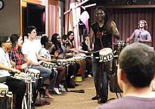 Photo of drummer leading a student drum ensemble.