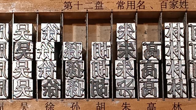shiny metal cubes with Chinese characters on them stacked on a shelf